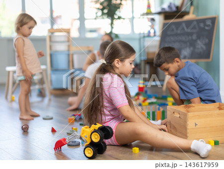 Kids playing with colorful educational toys on blurred kindergarten room background 143617959