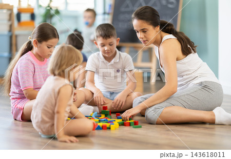 Kids playing with colorful educational toys on blurred kindergarten room background 143618011
