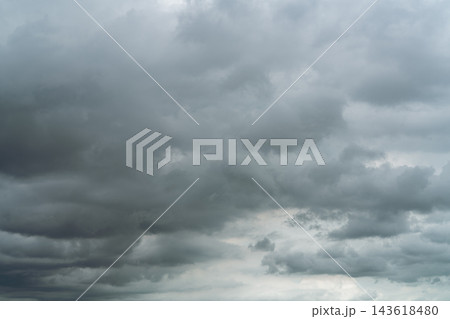 Dramatic dark storm clouds covering an overcast sky before heavy rain during the rainy season, creating a gloomy natural background for severe weather, climate, sadness and danger concepts. 143618480