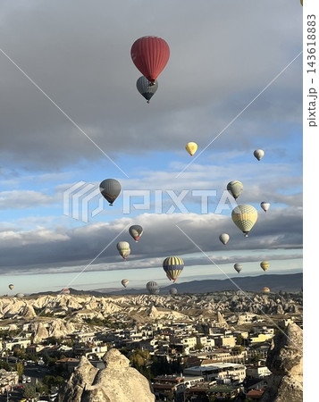 トルコ カッパドキア ギョレメ 雲の下を舞うカラフルな気球と朝の街並み トルコ カッパドキア ギョレメ 雲の下を舞うカラフルな気球と朝の街並み 143618883