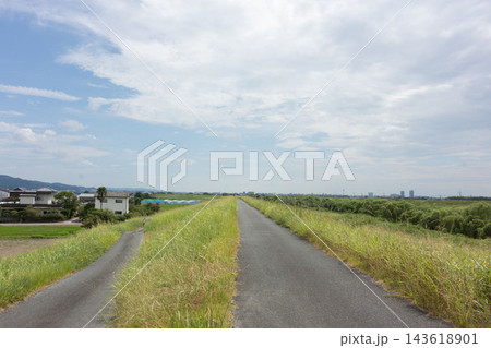 広い空と緑豊かな河川敷が広がる、のどかな郊外の風景 広い空と緑豊かな河川敷が広がる、のどかな郊外の風景 143618901
