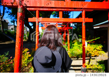 朱色の鳥居を参拝する女性の後ろ姿 143619928