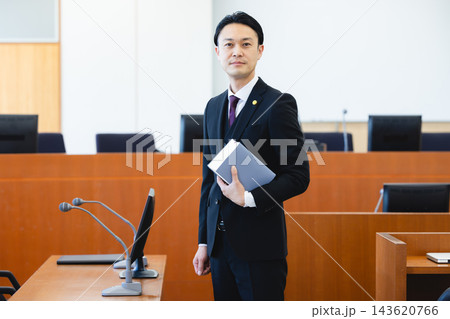 法廷で書類を持って立つスーツ姿の男性弁護士 法廷で書類を持って立つスーツ姿の男性弁護士 143620766