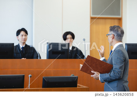 法廷で裁判官に向かって弁論する男性弁護士 法廷で裁判官に向かって弁論する男性弁護士 143620858