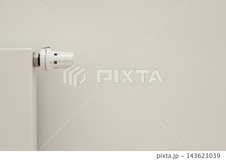A radiator valve is installed in a clean and simple room 143621039