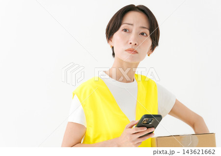 段ボールを持つ配達員の女性 段ボールを持つ配達員の女性 143621662