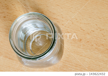 View of an empty glass jar on a wooden table View of an empty glass jar on a wooden table 143622432