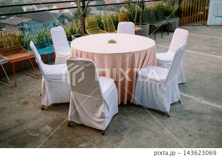 Outdoor Event Setup With Round Table And White Covered Chairs 143623069