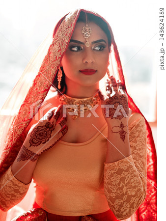 Thinking, Indian woman and wedding fashion by window with red saree, gold jewelry or makeup for beauty. Marriage ceremony, accessories or bride with culture for celebration, commit or hindu custom Thinking, Indian woman and wedding fashion by window with red saree, gold jewelry or makeup for beauty. Marriage ceremony, accessories or bride with culture for celebration, commit or hindu custom 143624189