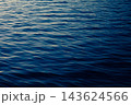 さざ波が立つ港の水面と夕方の日差し 143624566