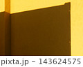 建物の影と黄色のコンクリートの壁のアップ 143624575