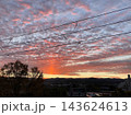 電線越しに広がる赤い朝焼け雲と山並みの風景 143624613
