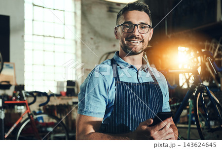 Bicycle, portrait and phone for man, garage and small business of mechanic, engineer or entrepreneur. Proud, owner or person with service maintenance for bike, technician or transport with mobile app Bicycle, portrait and phone for man, garage and small business of mechanic, engineer or entrepreneur. Proud, owner or person with service maintenance for bike, technician or transport with mobile app 143624645