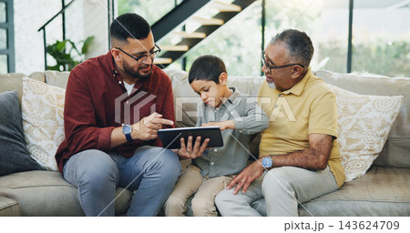 Tablet, sofa and child with dad and grandfather choose movie, video or film together. Happy, bonding and boy kid watching film on digital technology with father and senior man in living room at home. 143624709