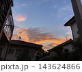 住宅街の屋根の向こうに広がるオレンジ色の朝焼け 143624866