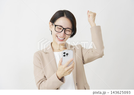スマホを見てビジネスウーマン ミドル ガッツポーズ 白背景 スマホを見てビジネスウーマン ミドル ガッツポーズ 白背景 143625093