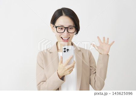 スマホを持って笑顔で驚くビジネスウーマン ミドル 白背景 スマホを持って笑顔で驚くビジネスウーマン ミドル 白背景 143625096