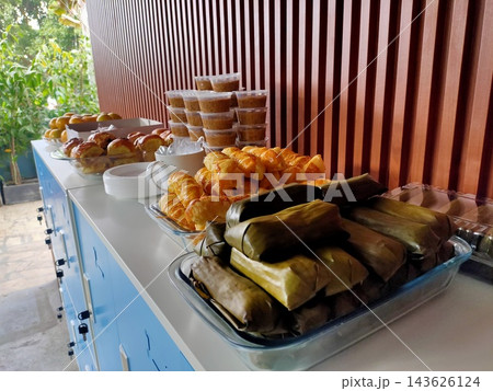 Event buffet spread featuring traditional Indonesian snacks, baked pastries, and fresh fruit Event buffet spread featuring traditional Indonesian snacks, baked pastries, and fresh fruit 143626124