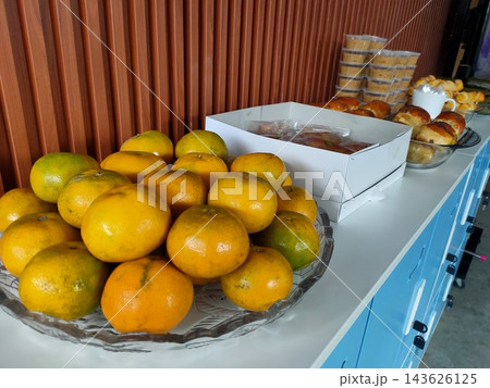 Event catering buffet with fresh oranges, baked bread rolls, and snacks on a table Event catering buffet with fresh oranges, baked bread rolls, and snacks on a table 143626125