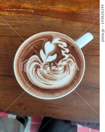 Cup of hot chocolate with latte art on a wooden table Cup of hot chocolate with latte art on a wooden table 143626144