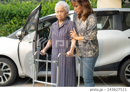 Caregiver help Asian elderly woman disability patient get in her car. Caregiver help Asian elderly woman disability patient get in her car. 143627511