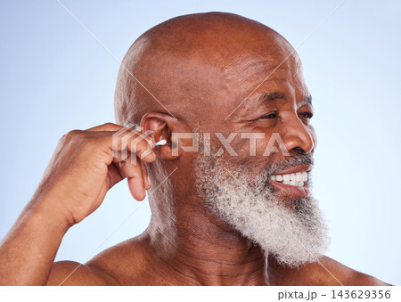 Studio, smile and black man with cotton swab for self care, hygiene maintenance and removal of wax. Happy, mature person and hand with product for ear health, cosmetics or cleaning on blue background 143629356