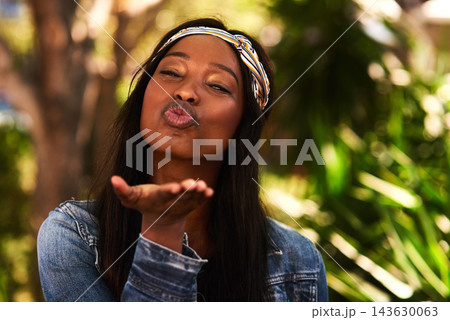 Black woman, blow kiss and portrait in park with symbol of love, care and kindness in summer sunshine. Girl, person and outdoor with pouting lips, emoji or sign on holiday in morning at urban garden Black woman, blow kiss and portrait in park with symbol of love, care and kindness in summer sunshine. Girl, person and outdoor with pouting lips, emoji or sign on holiday in morning at urban garden 143630063