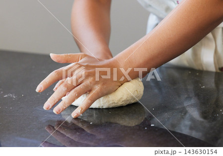 Person, hands and kneading dough in kitchen or baking bread for morning breakfast, cooking or dessert. Chef, counter and wheat production for pizza meal or learning recipe, preparing or restaurant 143630154