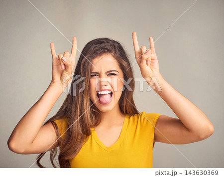 Woman, portrait and devil horns with hands in studio for grunge sign, tongue out or rock gesture on white background. Crazy, aesthetic and edgy female model for emoji, punk icon or rebel symbol Woman, portrait and devil horns with hands in studio for grunge sign, tongue out or rock gesture on white background. Crazy, aesthetic and edgy female model for emoji, punk icon or rebel symbol 143630369