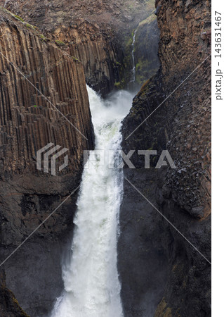 Litlanesfoss waterfall plunging between tall basalt columns in East Iceland Litlanesfoss waterfall plunging between tall basalt columns in East Iceland 143631467