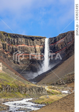 Hengifoss Waterfall and Red Basalt Cliffs Above a Summer River Valley in Iceland Hengifoss Waterfall and Red Basalt Cliffs Above a Summer River Valley in Iceland 143631495
