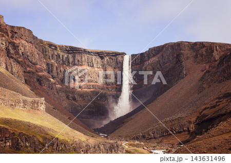 Hengifoss waterfall and red basalt layers in a warm toned Iceland summer landscape Hengifoss waterfall and red basalt layers in a warm toned Iceland summer landscape 143631496