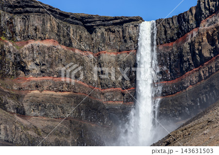 Hengifoss waterfall beside red sedimentary bands in basalt cliffs, Iceland Hengifoss waterfall beside red sedimentary bands in basalt cliffs, Iceland 143631503