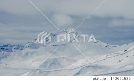 Snow-covered mountain peak over sweeping glacial valley with smooth snowfields and rocky ridges Snow-covered mountain peak over sweeping glacial valley with smooth snowfields and rocky ridges 143631689