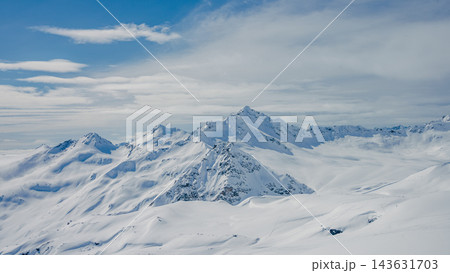 Panoramic snow-covered Mount Elbrus and surrounding Caucasus peaks under layered cloud sky, high-altitude alpine landscape, winter Panoramic snow-covered Mount Elbrus and surrounding Caucasus peaks under layered cloud sky, high-altitude alpine landscape, winter 143631703