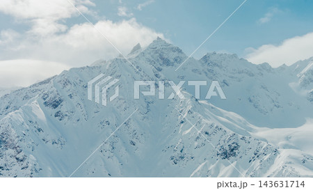 Mount Elbrus snow-covered summit and rugged Caucasus ridges under blue sky panorama Mount Elbrus snow-covered summit and rugged Caucasus ridges under blue sky panorama 143631714