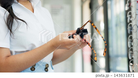 Hands, glasses and cloth at shop for optometry, vision and wellness for eyesight, cleaning and dirt. Woman, customer and fabric for dust with inspection for eye care, health or style at retail store 143631871