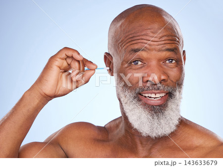 Studio, portrait and black man with cotton swab for hygiene, self care maintenance and removal of wax. Happy, mature person and smile with product for cosmetics, health or cleaning on blue background 143633679
