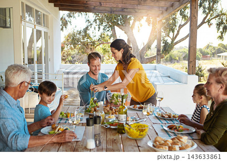 Happy family, eating and food with relax outdoor on patio with conversation, bonding and healthy meal in summer. Parents, grandparents and kids at dining table in backyard of home with talking or fun Happy family, eating and food with relax outdoor on patio with conversation, bonding and healthy meal in summer. Parents, grandparents and kids at dining table in backyard of home with talking or fun 143633861