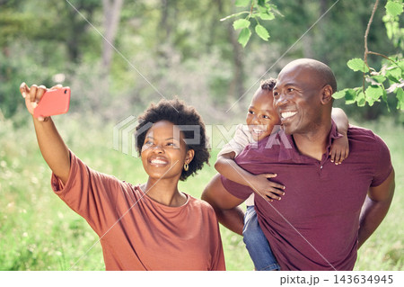 Selfie, black family and smile in nature with child, picture and memory for social media, travel and holiday. Vacation, woman and man with happiness, photography and piggyback of kid with parents 143634945