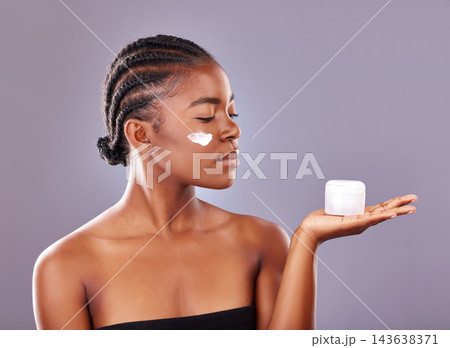 Black woman, cosmetics and beauty with moisturizer, product and cream for results in studio backdrop. African, female person and smile for skincare, pride and glow for dermatology in gray background Black woman, cosmetics and beauty with moisturizer, product and cream for results in studio backdrop. African, female person and smile for skincare, pride and glow for dermatology in gray background 143638371