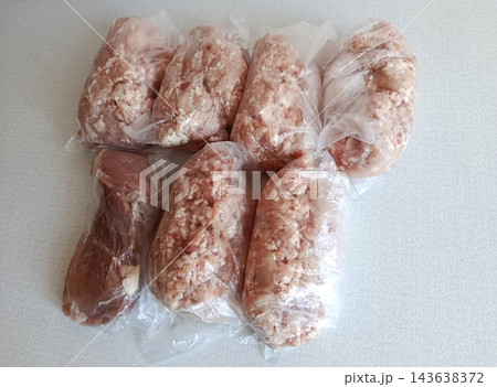 Various portions of raw minced pork and beef in clear plastic bags, prepared for freezing and bulk storage, facilitating meal preparation and efficient food management Various portions of raw minced pork and beef in clear plastic bags, prepared for freezing and bulk storage, facilitating meal preparation and efficient food management 143638372