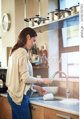 Cleaning, woman and dishes in kitchen for hygiene, routine and coffee mug. Female person, washing with water and sponge for disinfecting, bacteria protection and sink at home with soap for germs 143639783