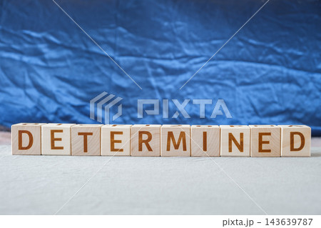 motivational word Determined, from letters on wooden cubes motivational word Determined, from letters on wooden cubes 143639787