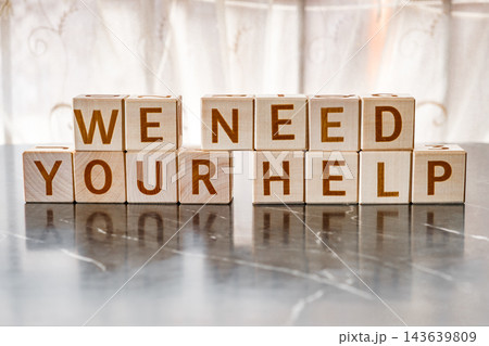 motivational word We need your help, from letters on wooden cubes motivational word We need your help, from letters on wooden cubes 143639809