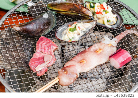 seafood is cooked on a charcoal grill 143639822