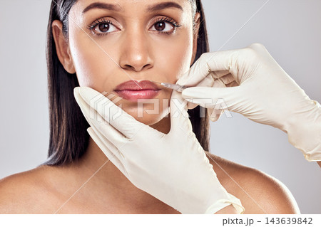 Woman, cosmetics and injection with lip filler in surgery for wellness, health and face products. Female person, skincare and cosmetology for results, dermatology or glowing skin in studio backdrop 143639842