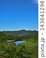 青空と緑の山々に囲まれた湿原の池 143641298