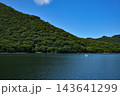 青空と緑の山々に囲まれた湖を進むスワンボート 143641299