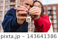 Closeup Happy Couple Smiling And Holding Keys With House Keychain Toward Camera Outside Apartment Building. First Home Purchase, Mortgage And Homeownership Concept. 143641386